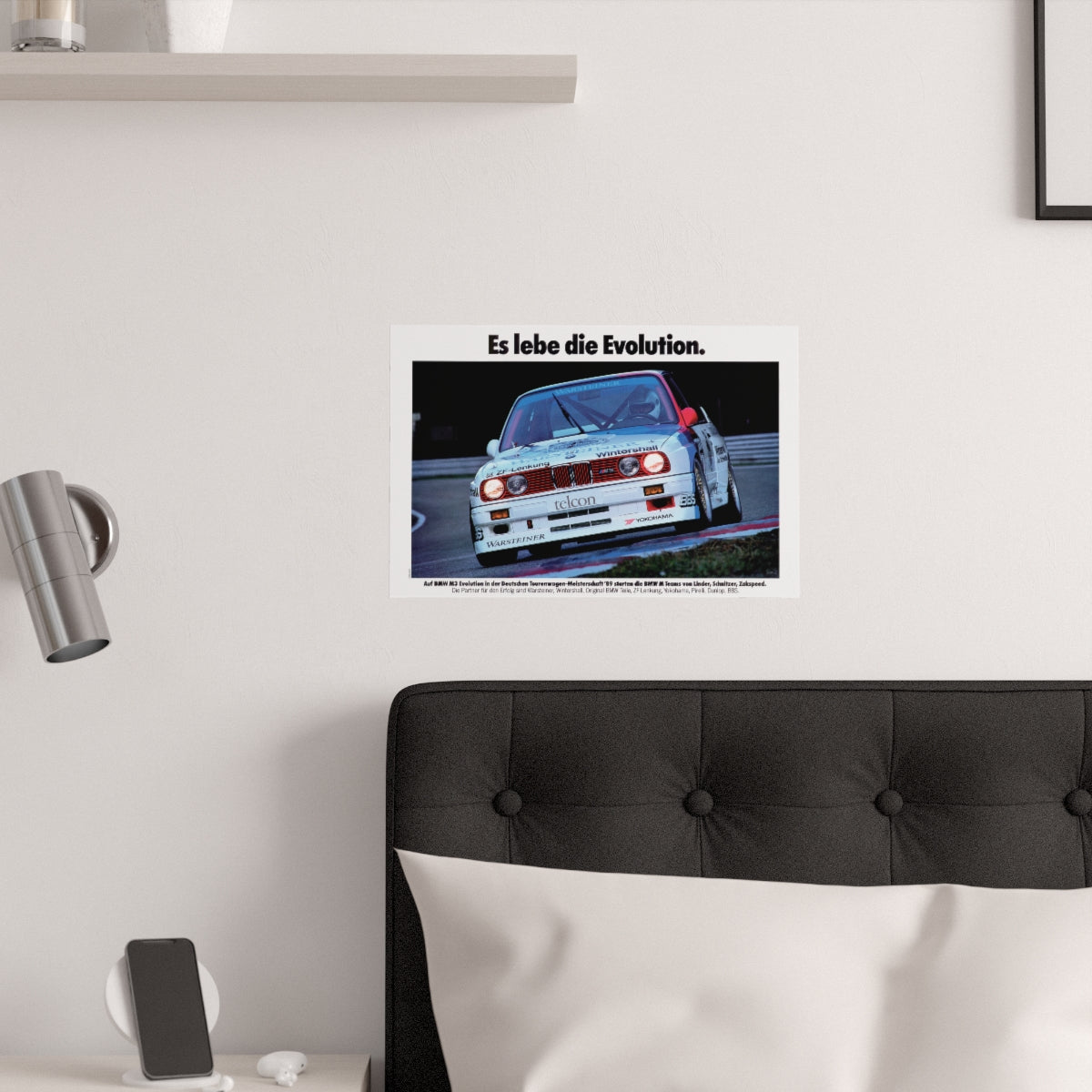 BMW E30 M3 shown in motion, racing on a track. Title above the photo reads Long live Evolution. The poster is displayed in a white bedroom and placed over dark gray headboard.