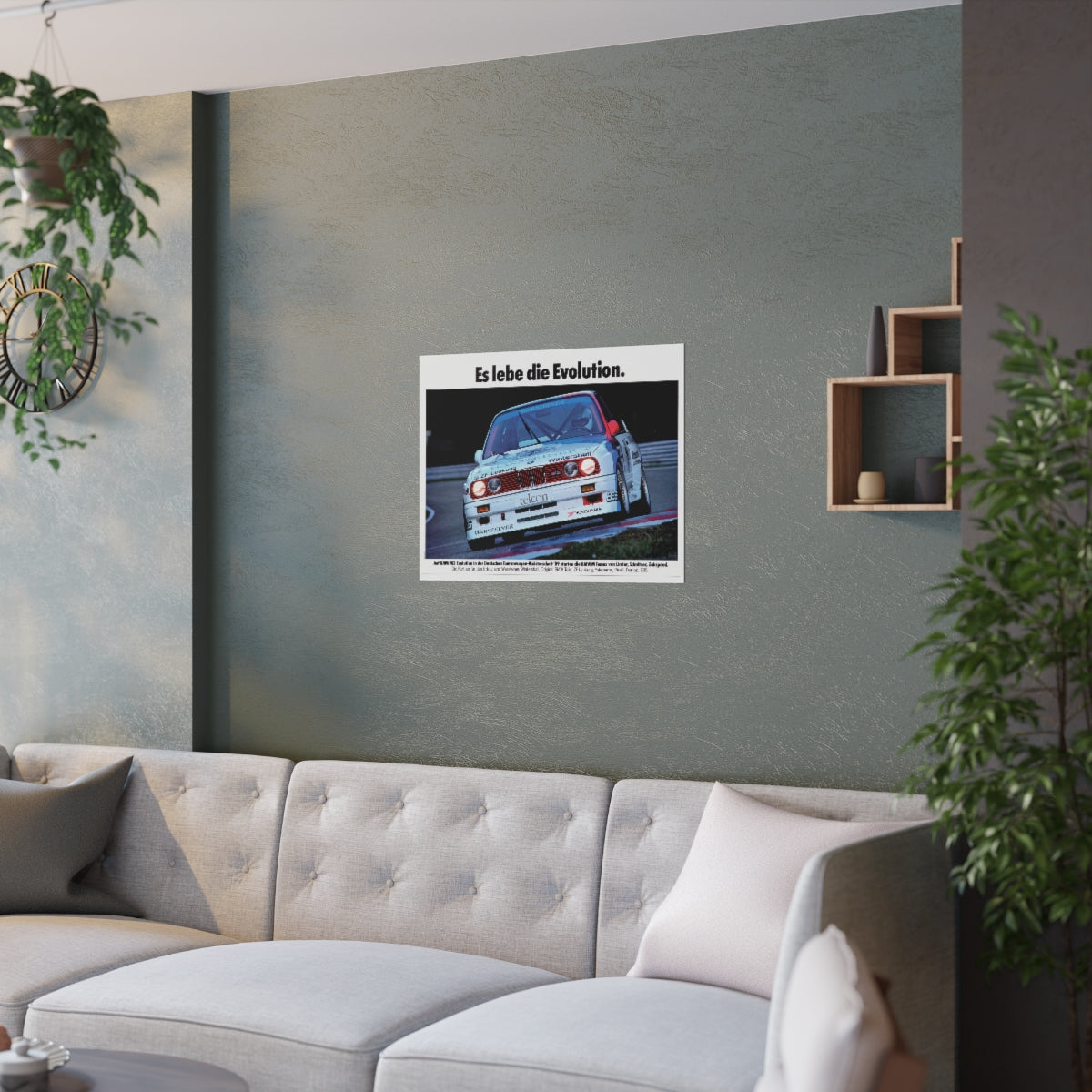 BMW E30 M3 shown in motion, racing on a track. Title above the photo reads Long live Evolution. The poster is displayed in a green living room and is hanging over white couch.