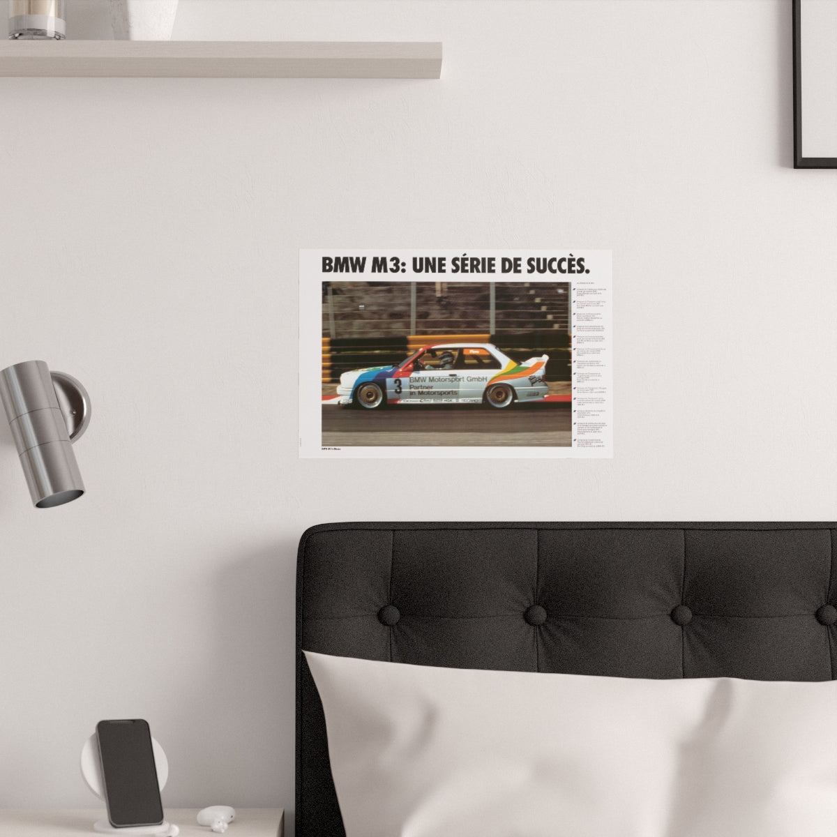 BMW E30 M3 shown in motion, racing on a track. Title above the photo reads BMW M3 a series of successes. The poster is displayed in a white bedroom and placed over dark gray headboard.